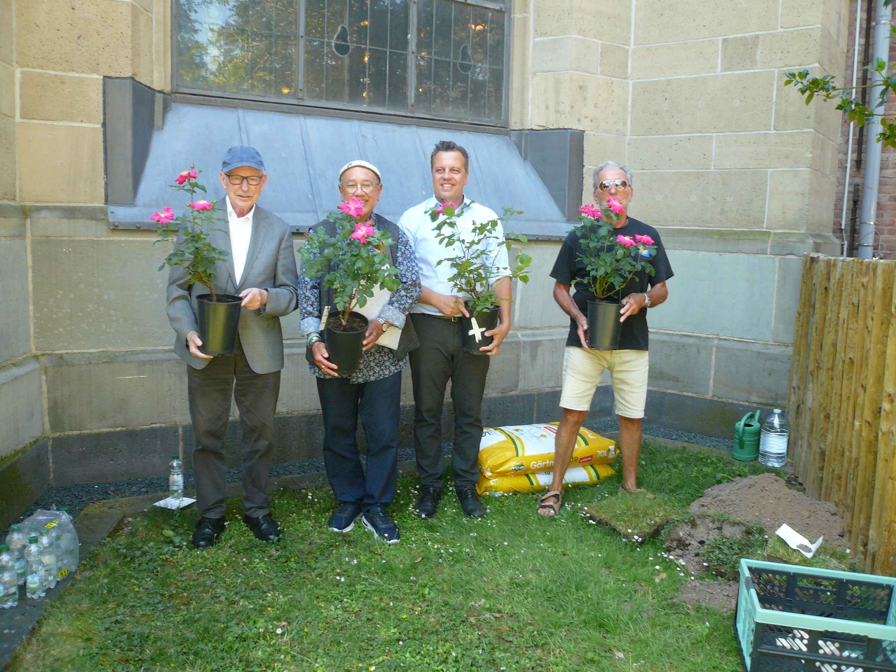 von links: Msgr. Pfarrer Anno Burghof,
 Dr. Norman Sinclair,
 Bürgermeister Sacha Reichelt und Herbergsvater Gerd Weinand mit den Pilgerrosen